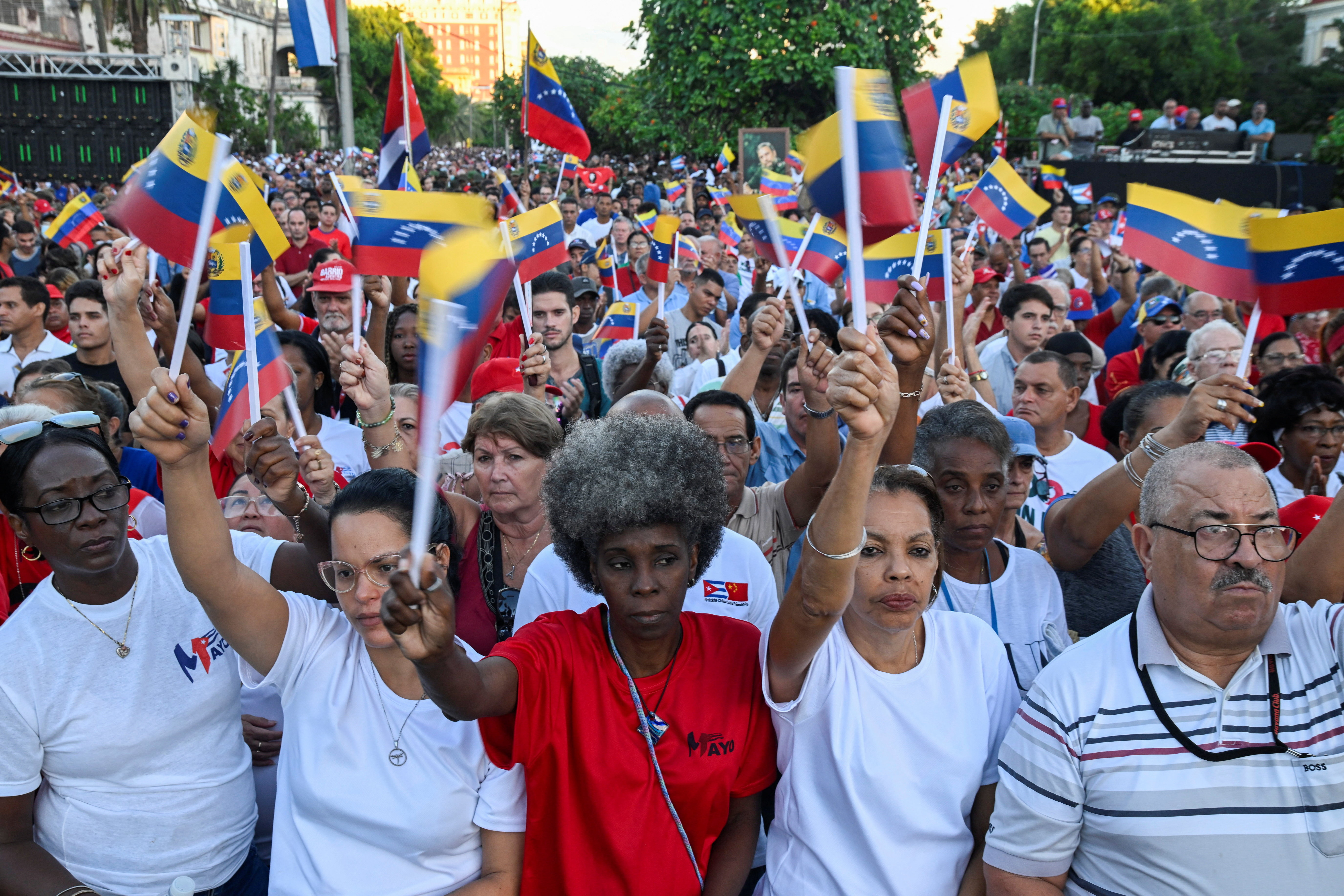 Colombia recalls U.S. ambassador after Trump threats on tariffs, aid 7 Hundreds of people are shown outdoors in an apparent demonstration, many waving small blue, yellow and red flags.